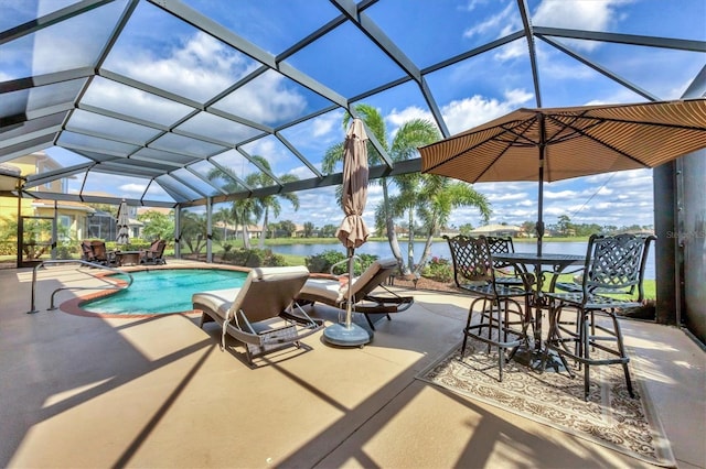 pool featuring glass enclosure, a patio, and a water view