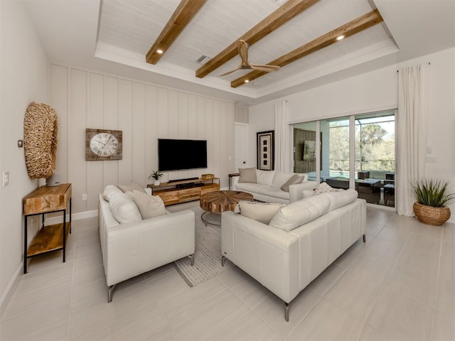 living area with light tile patterned floors, beam ceiling, and baseboards