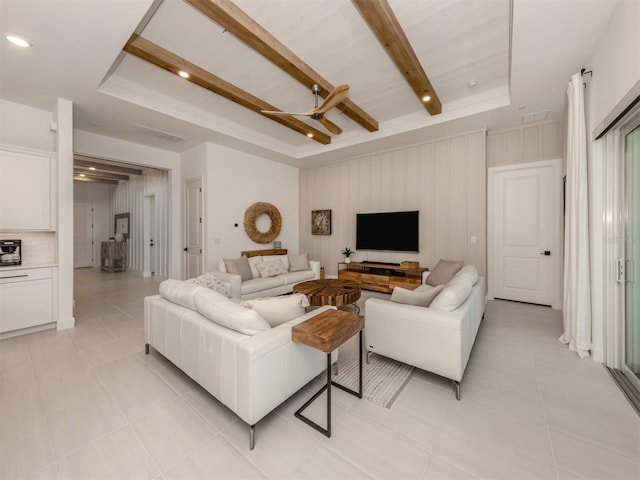 living room featuring light tile patterned floors, a tray ceiling, visible vents, and beam ceiling