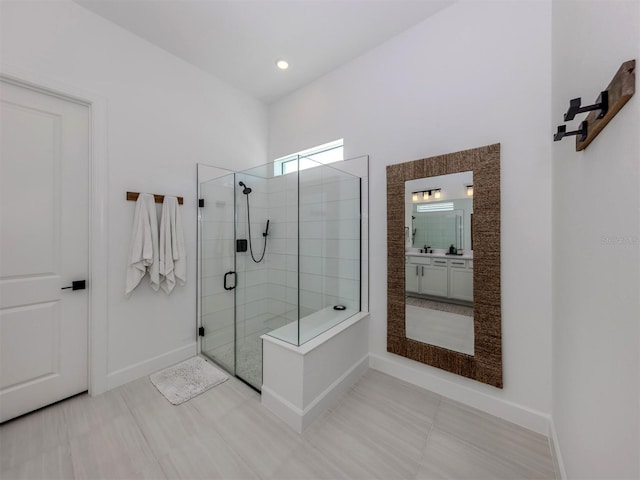 full bathroom featuring tile patterned floors, a shower stall, baseboards, and vanity