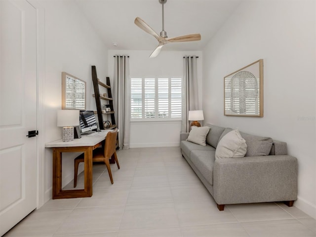 office space featuring a ceiling fan, lofted ceiling, light tile patterned flooring, and baseboards