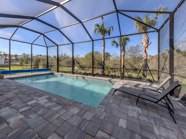 outdoor pool with glass enclosure and a patio area