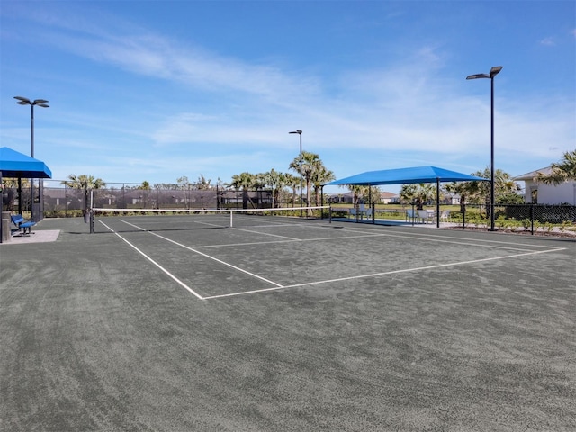 view of tennis court featuring fence