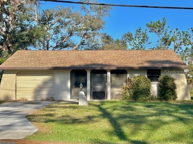 ranch-style house featuring roof with shingles, stucco siding, an attached garage, a front yard, and driveway