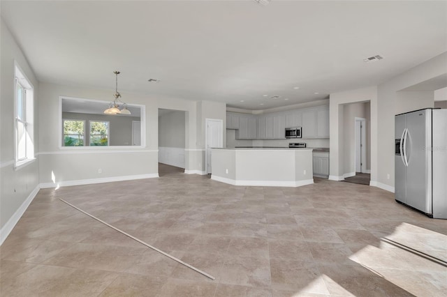 unfurnished living room with visible vents and baseboards