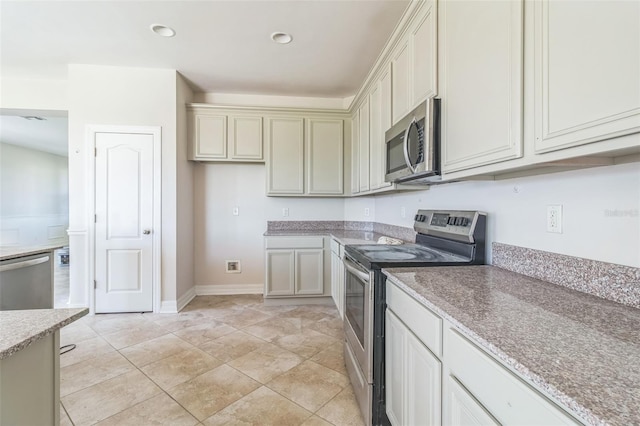 kitchen with light tile patterned floors, cream cabinets, appliances with stainless steel finishes, and recessed lighting