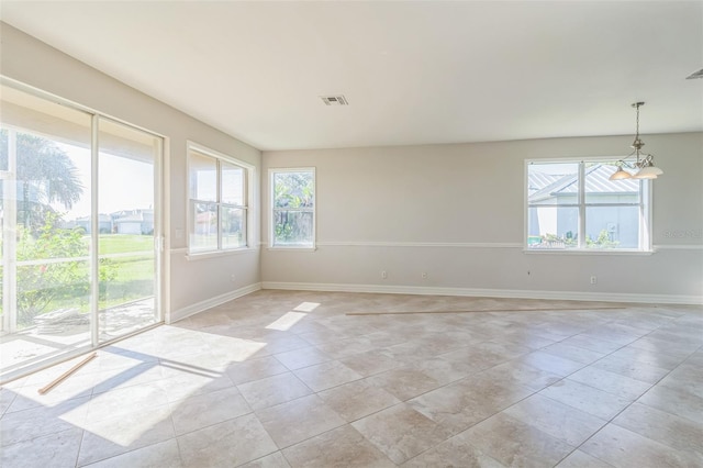 unfurnished room featuring a wealth of natural light, visible vents, and baseboards