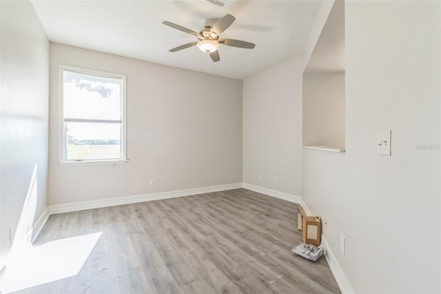 unfurnished room featuring light wood-type flooring, baseboards, and a ceiling fan