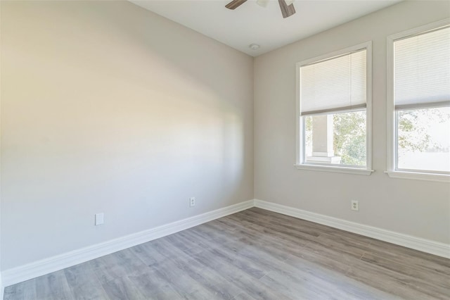 unfurnished room with light wood-style floors, baseboards, and a ceiling fan