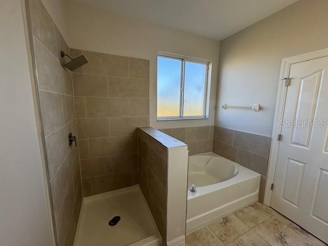 bathroom with tiled shower and a garden tub