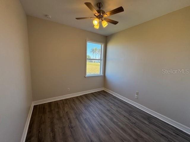 empty room featuring dark wood finished floors, baseboards, and ceiling fan