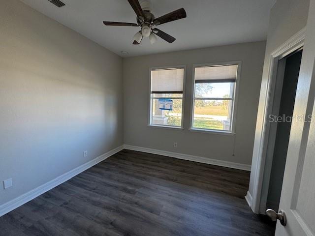 unfurnished bedroom with ceiling fan, dark wood-style flooring, and baseboards