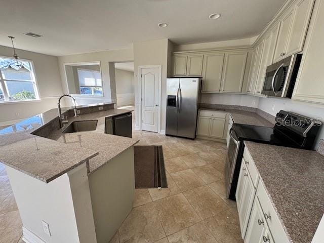 kitchen with a kitchen island, appliances with stainless steel finishes, hanging light fixtures, light stone countertops, and a sink