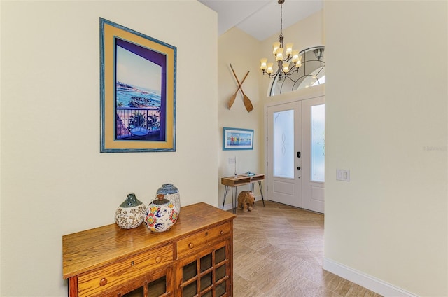 foyer entrance featuring french doors, a notable chandelier, and baseboards