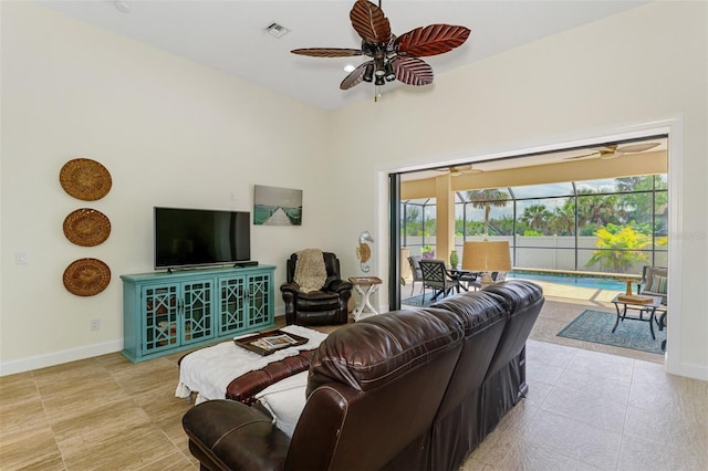 living area featuring a healthy amount of sunlight, a sunroom, visible vents, and a ceiling fan