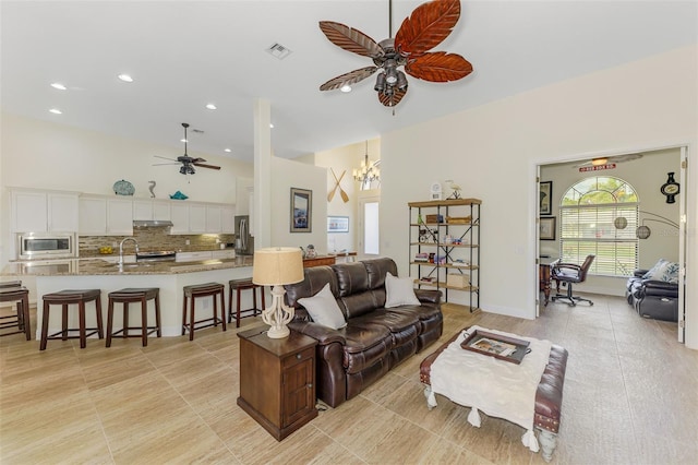 living room featuring recessed lighting, visible vents, baseboards, and ceiling fan with notable chandelier