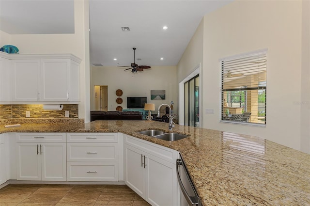 kitchen featuring visible vents, dishwasher, a sink, white cabinetry, and backsplash