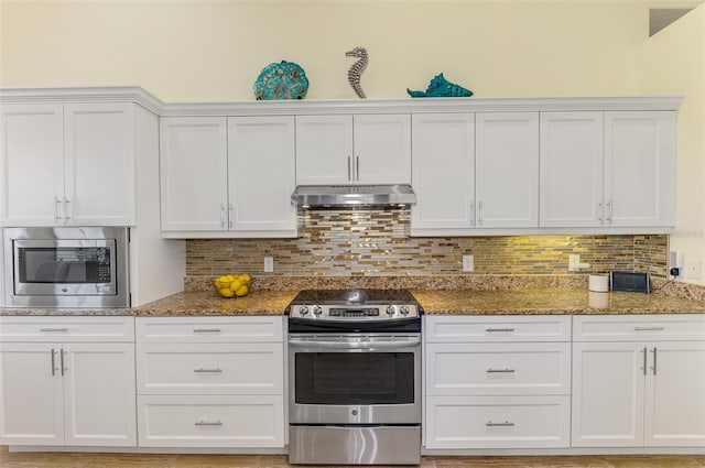 kitchen with white cabinets, light stone counters, appliances with stainless steel finishes, under cabinet range hood, and backsplash