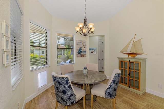 dining room with a chandelier, light wood-style flooring, and baseboards