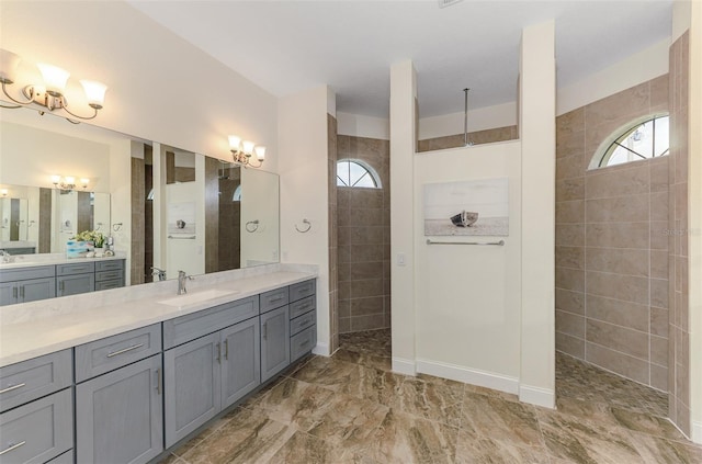 bathroom featuring baseboards, walk in shower, a wealth of natural light, and vanity