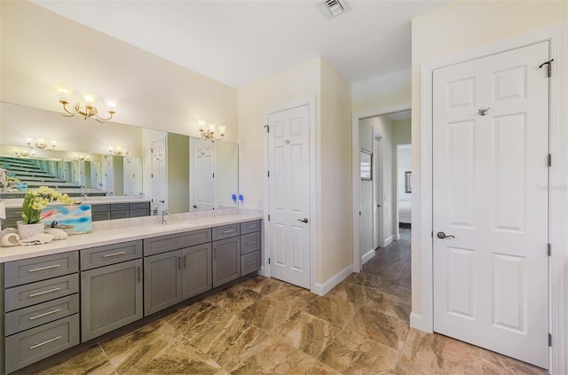 ensuite bathroom featuring a notable chandelier, visible vents, ensuite bathroom, vanity, and baseboards