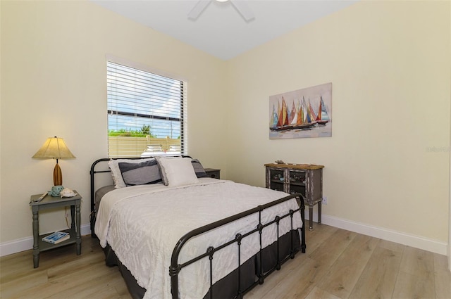 bedroom with light wood-type flooring, ceiling fan, and baseboards