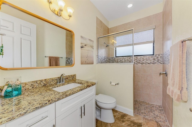 bathroom featuring toilet, a walk in shower, and vanity