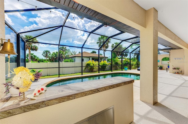 pool with glass enclosure, fence, and a patio