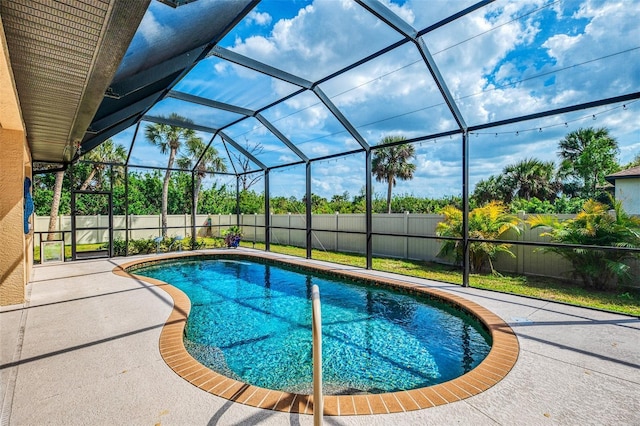 view of pool featuring glass enclosure, a patio area, a fenced backyard, and a fenced in pool