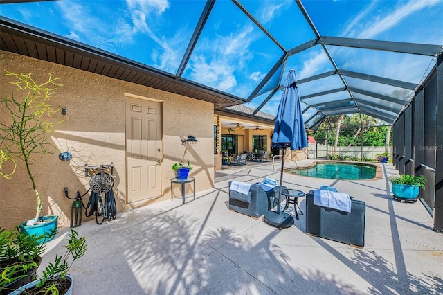 view of patio / terrace with a lanai, a ceiling fan, and a fenced in pool