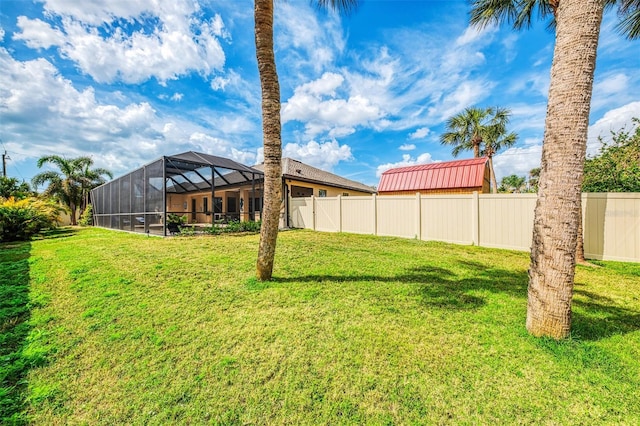 view of yard with a lanai and a fenced backyard