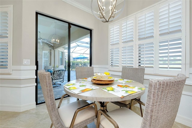 dining space featuring light tile patterned floors, ornamental molding, a sunroom, and an inviting chandelier