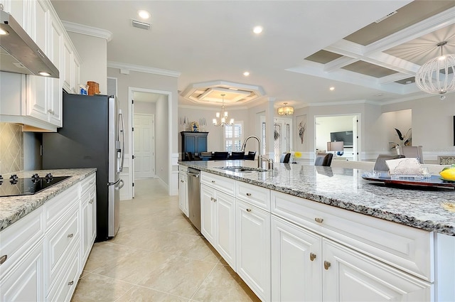 kitchen featuring visible vents, wall chimney exhaust hood, appliances with stainless steel finishes, a sink, and a notable chandelier