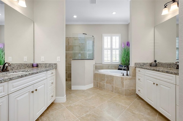 bathroom featuring two vanities, a garden tub, a sink, and walk in shower