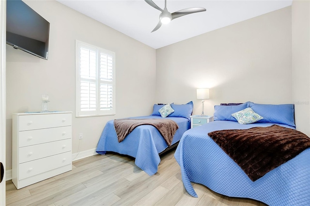 bedroom with ceiling fan, wood finished floors, and baseboards