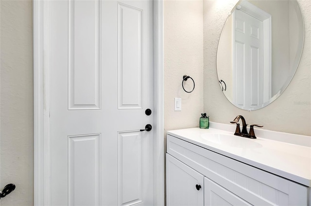 bathroom with a textured wall and vanity