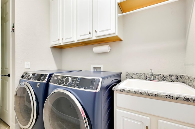 washroom with independent washer and dryer, a sink, and cabinet space