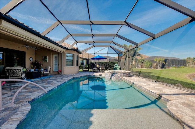 view of pool featuring a ceiling fan, glass enclosure, a pool with connected hot tub, and a patio area