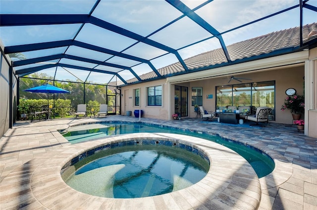 view of swimming pool with glass enclosure, outdoor lounge area, a pool with connected hot tub, a ceiling fan, and a patio area