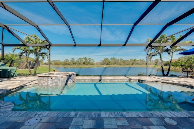 view of pool featuring glass enclosure, a patio area, a pool with connected hot tub, and a water view