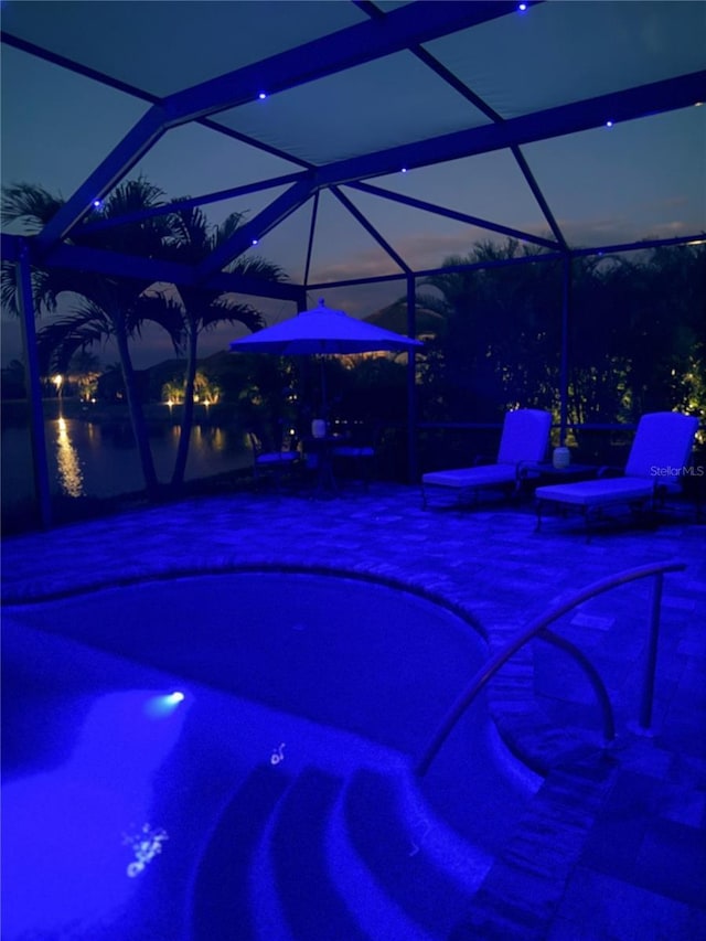 view of swimming pool featuring a patio, a lanai, and a pool with connected hot tub