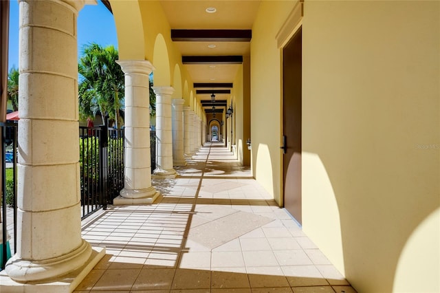 view of exterior entry with a balcony and stucco siding