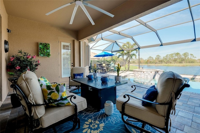 view of patio / terrace with outdoor dining area, a water view, a lanai, and a ceiling fan