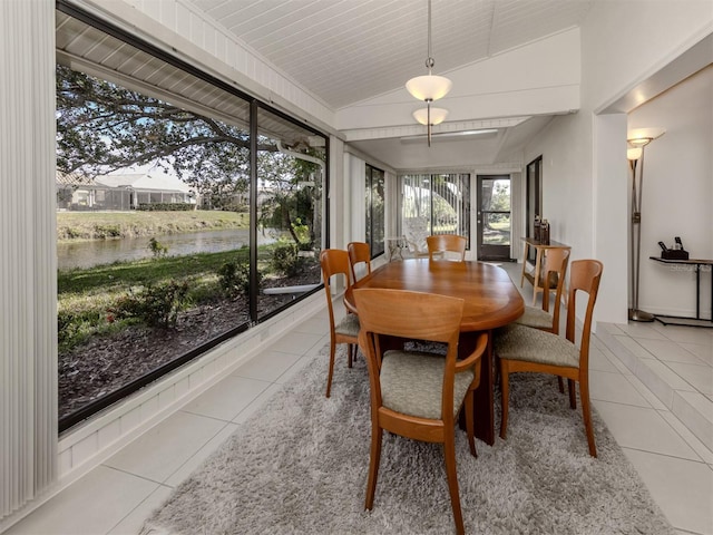 sunroom with lofted ceiling and a water view