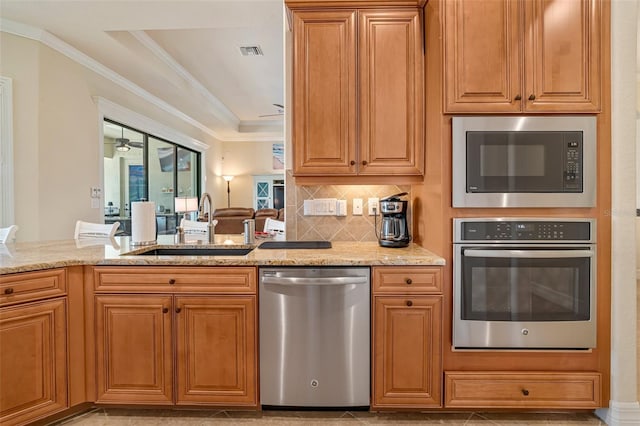 kitchen with crown molding, visible vents, appliances with stainless steel finishes, a ceiling fan, and a sink