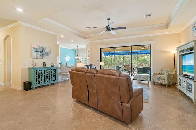 living area featuring visible vents, a tray ceiling, arched walkways, and ceiling fan with notable chandelier