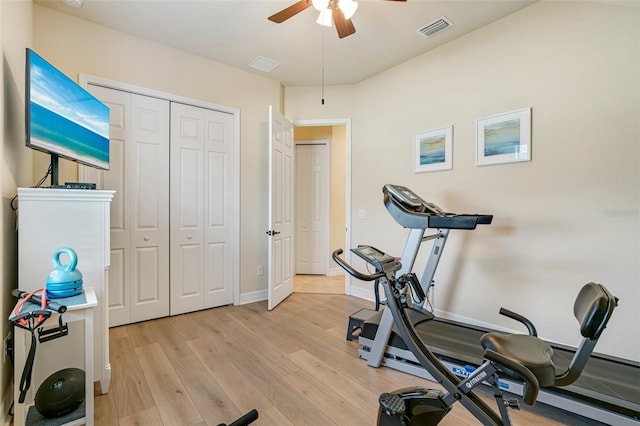 workout area featuring light wood-style floors, visible vents, baseboards, and a ceiling fan