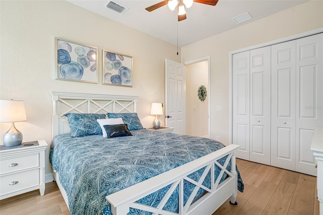 bedroom with light wood-style flooring, a closet, and visible vents