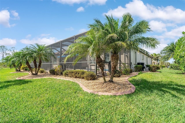 view of side of home with a lanai and a yard