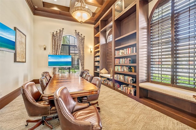 carpeted office with plenty of natural light, built in shelves, ornamental molding, and baseboards